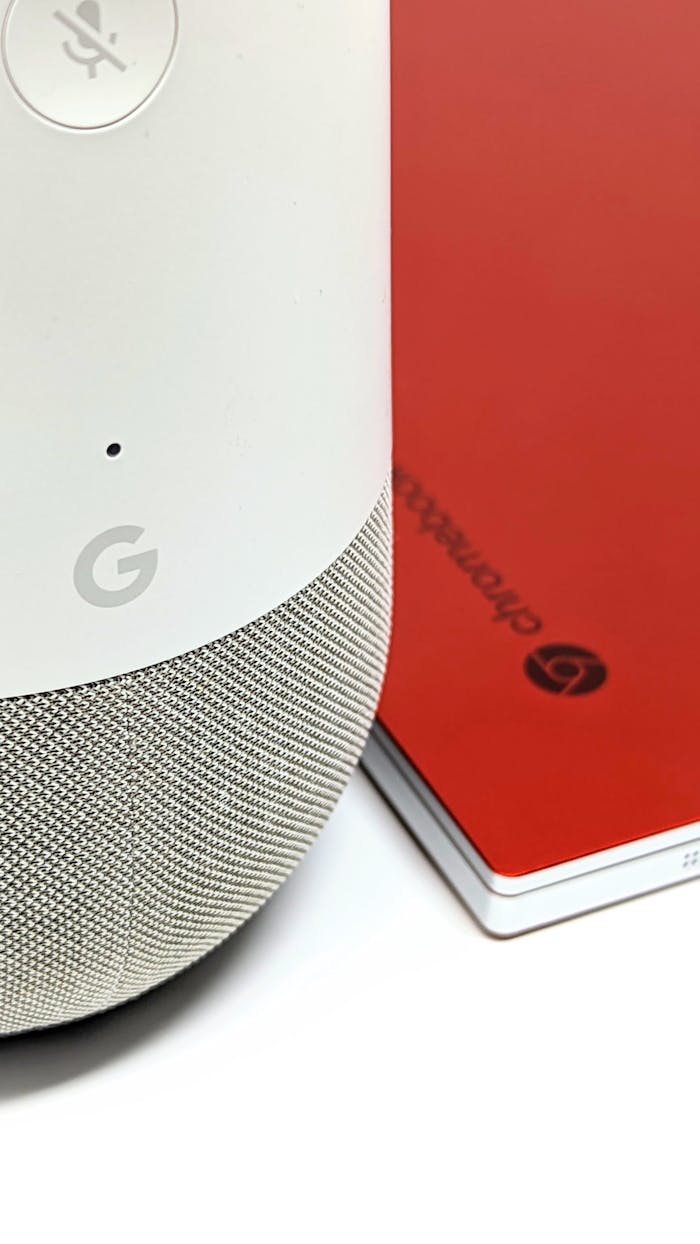 A smart home speaker next to a red notebook, showcasing modern tech accessories.