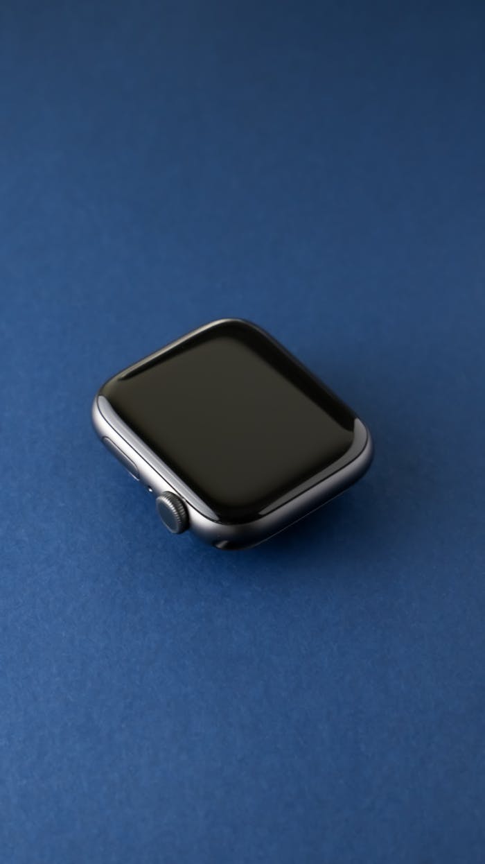 Close-up of a sleek black smartwatch on a vibrant blue surface.